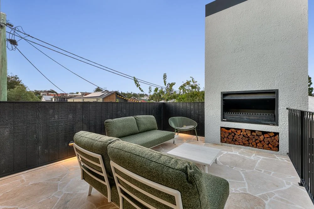 Outdoor terrace with fireplace at New Farm Queenslander