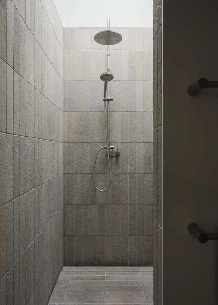 Family bathroom with oval bath limestone and brushed metal finishes