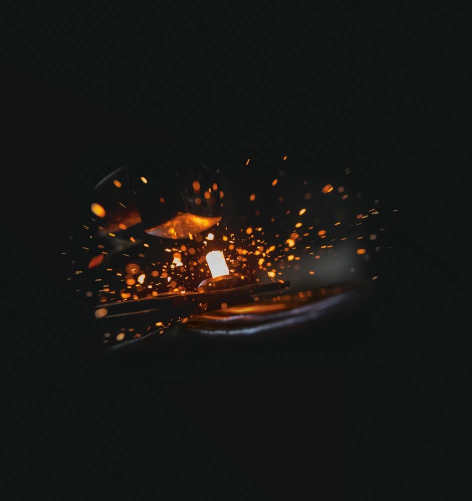 Hot metal being forged as sparks fly, reflecting Gaggenau’s origins in metalworking.