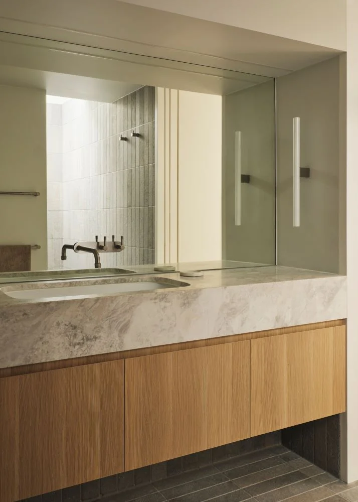 Contemporary ensuite with limestone and timber-toned cabinetry